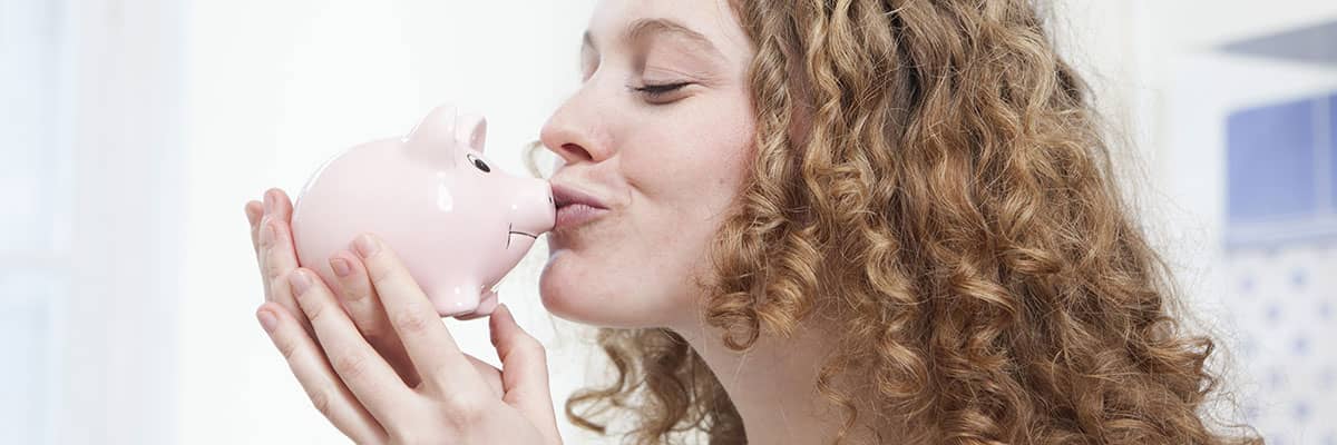 Energie sparen: Frau küsst Sparschwein, Verbraucherzentrale Energieberatung