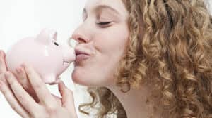 Energie sparen ist Geld sparen: Frau küsst Sparschwein